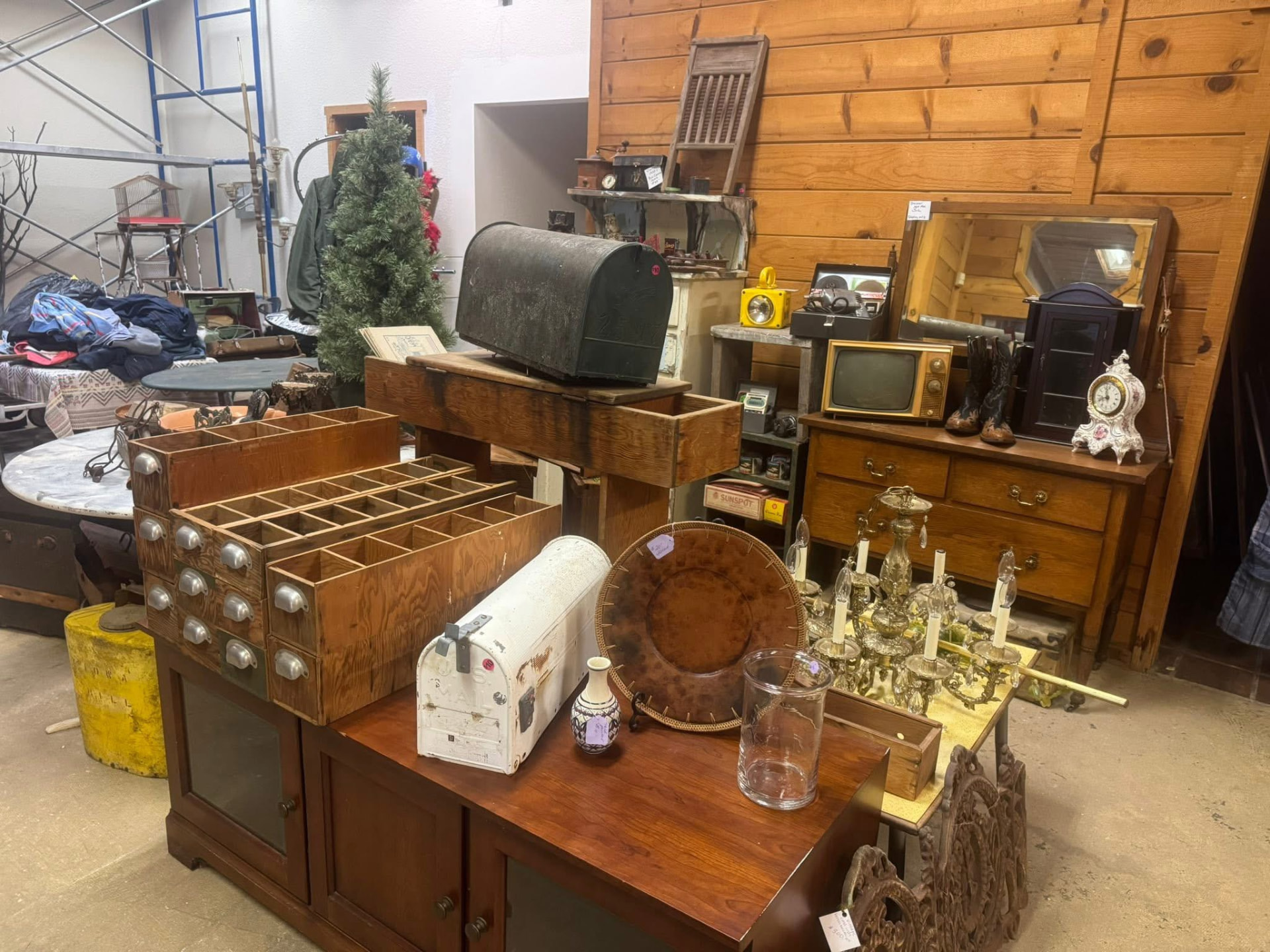 Antique furniture, mailboxes, a vintage TV, and a chandelier packed into a booth.