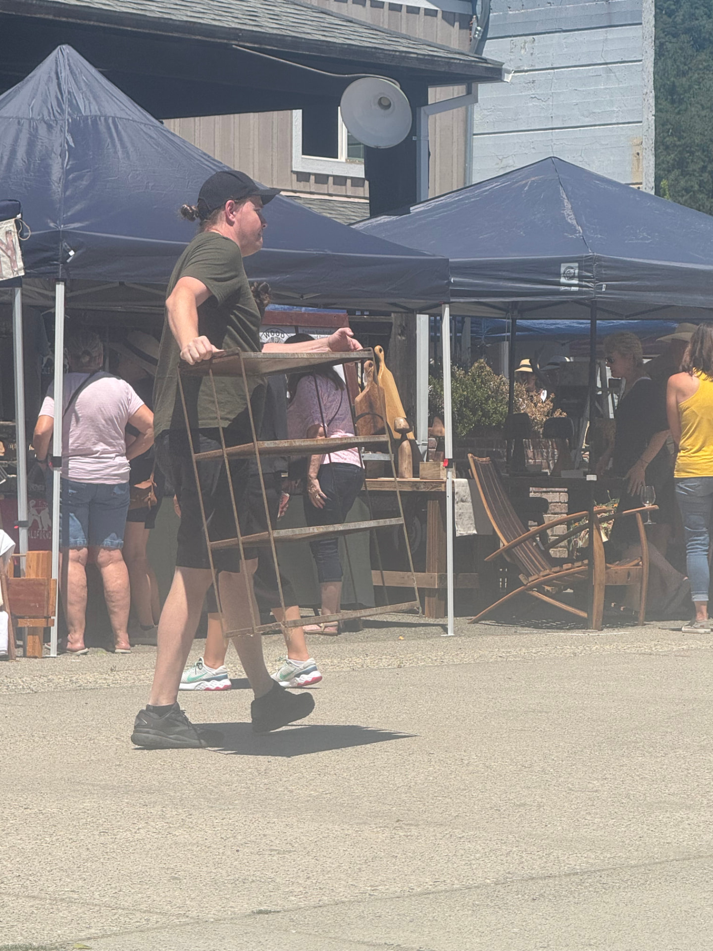 A shopper carrying home a rustic antique rack from the market.