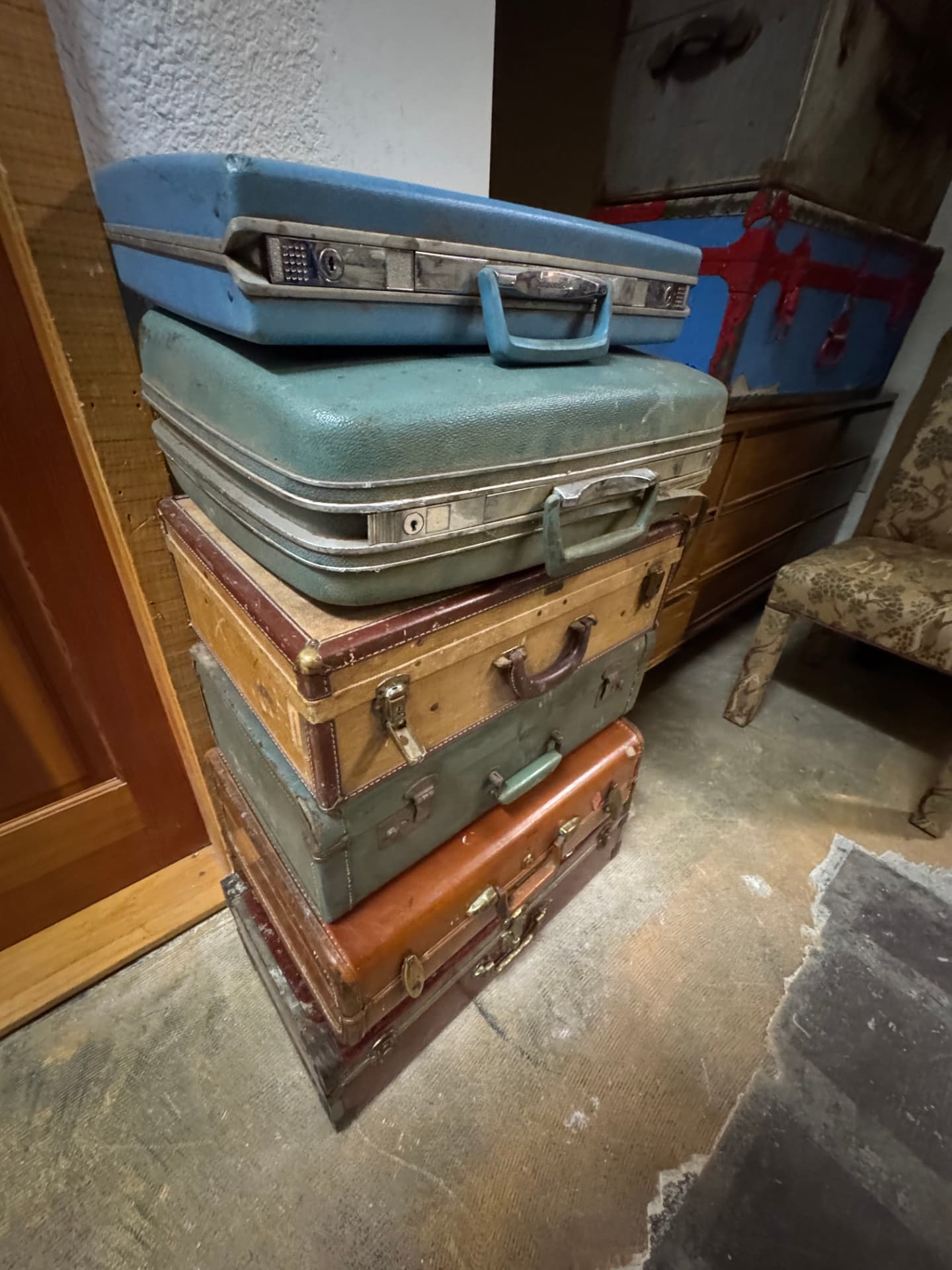 A tall stack of vintage suitcases in blue, tan, and leather brown.