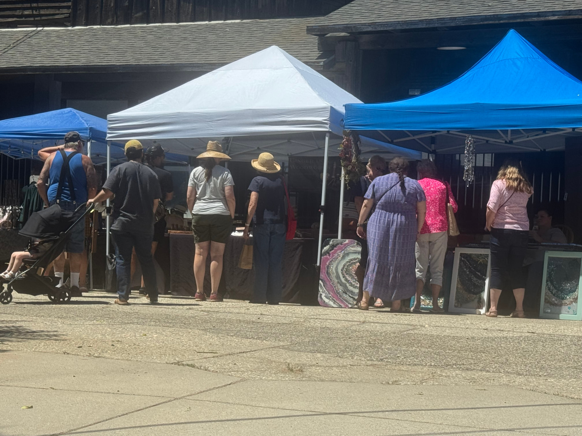 Shoppers browsing booths under canopies at The Colfax Bazaar.